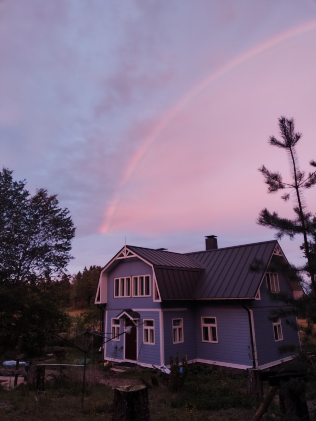 Sininen Biskopsdalin päärakennus sateenkaaren alla.